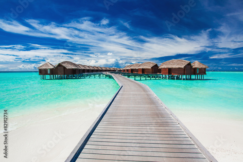 Overwater villas on the tropical lagoon connected by jetty