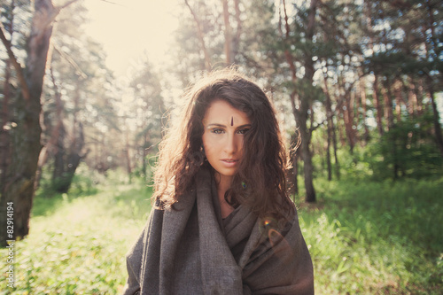 Portrait of a beautiful girl in a gray hooded in the forest