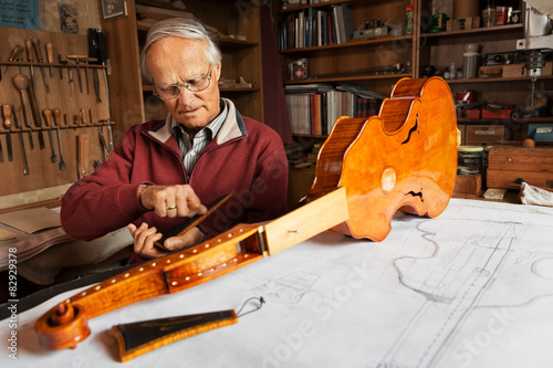 Elderly person building a viola d‘amore photo