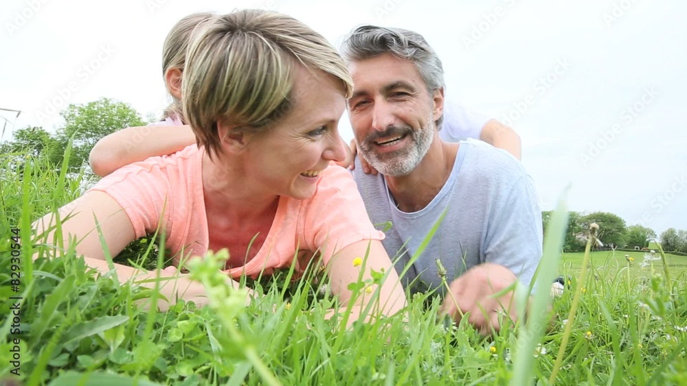 Portrait of family laying down in grass Portrait of family laying down in grass