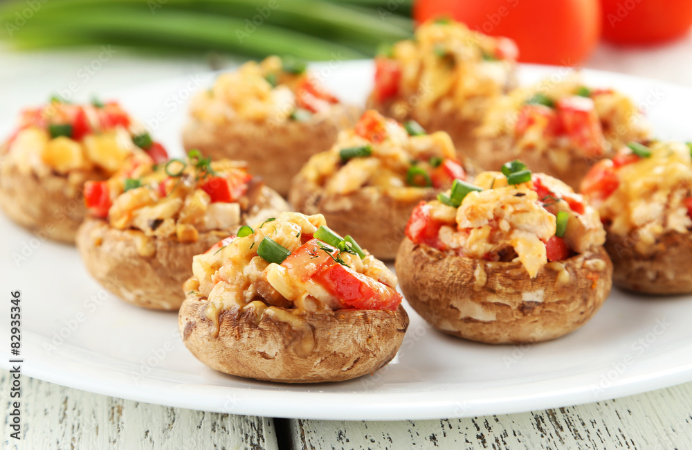 Stuffed mushrooms on plate on white wooden background Stuffed mushrooms on plate on white wooden background