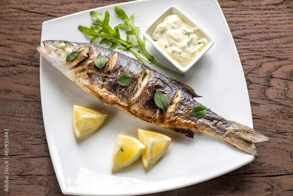 Grilled seabass on the wooden board Grilled seabass on the wooden board