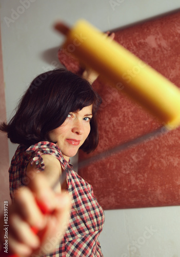 beautiful woman prepare to hang wallpaper photo
