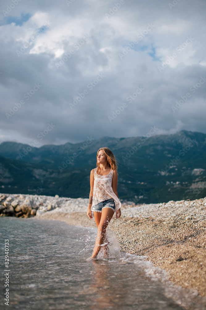 dreamy fashion girl walk on beach with mountains background dreamy fashion girl walk on beach with mountains background