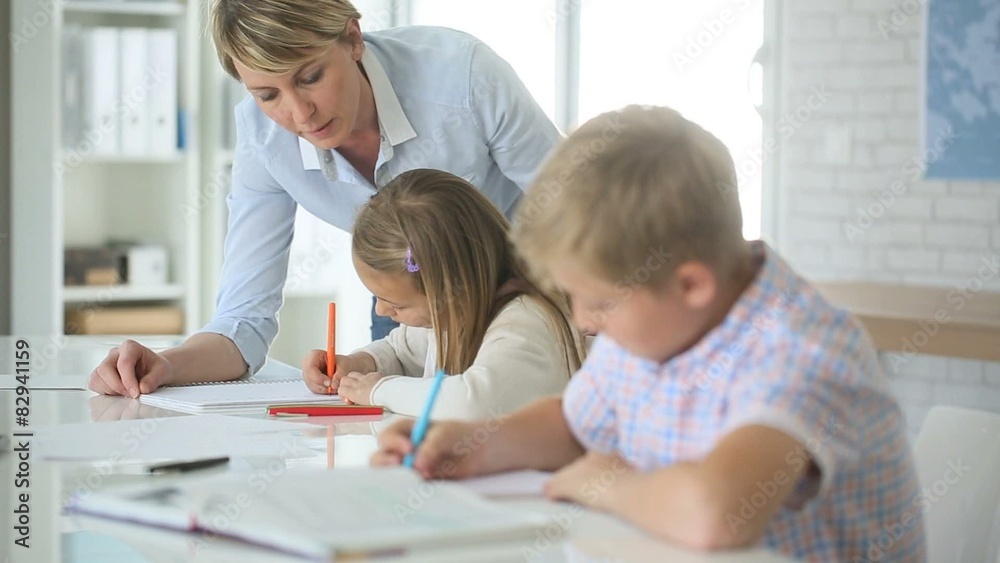 Teacher helping kids in classroom Teacher helping kids in classroom