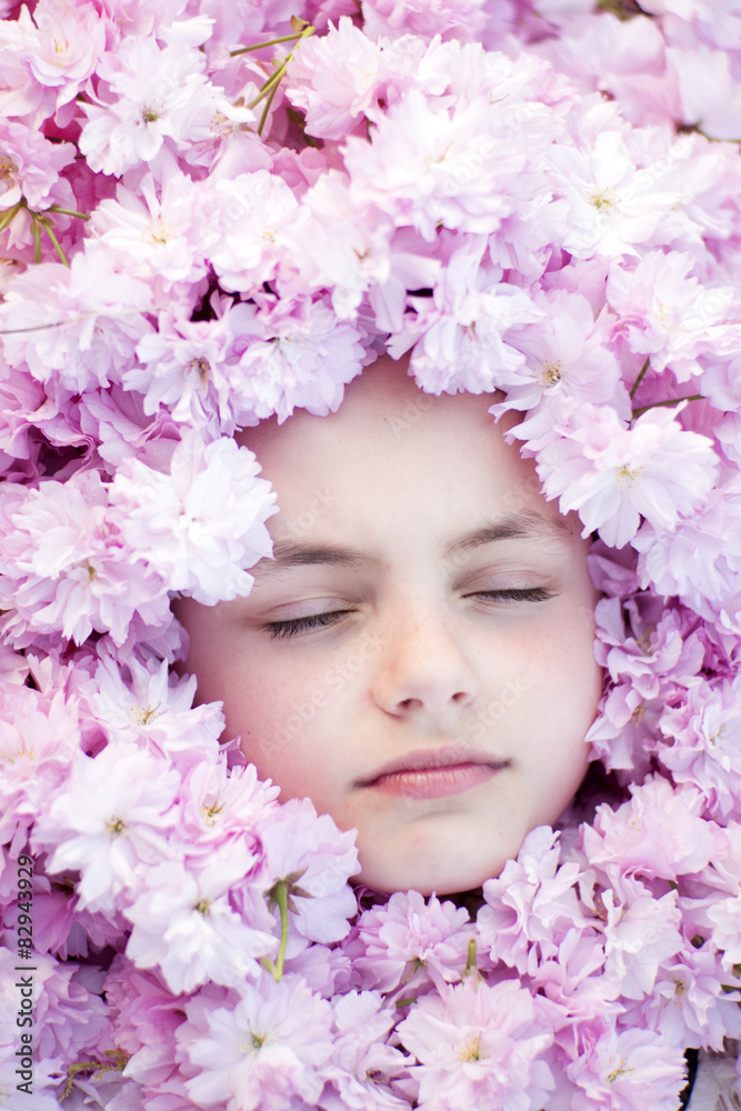 Face of small girl among flowers