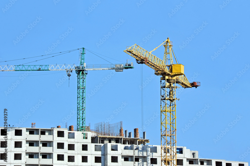 Crane and building construction site against blue sky