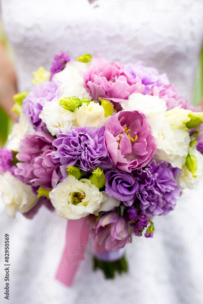 bride holding bridal bouquet with white, pink and purple flowers bride holding bridal bouquet with white, pink and purple flowers