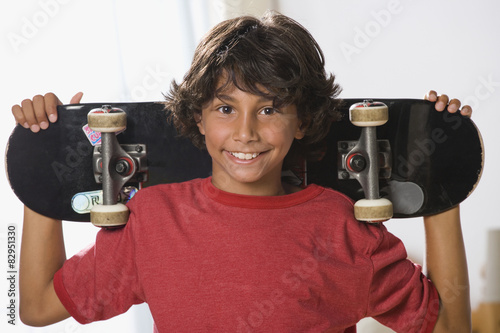 Mixed Race boy holding skateboard photo