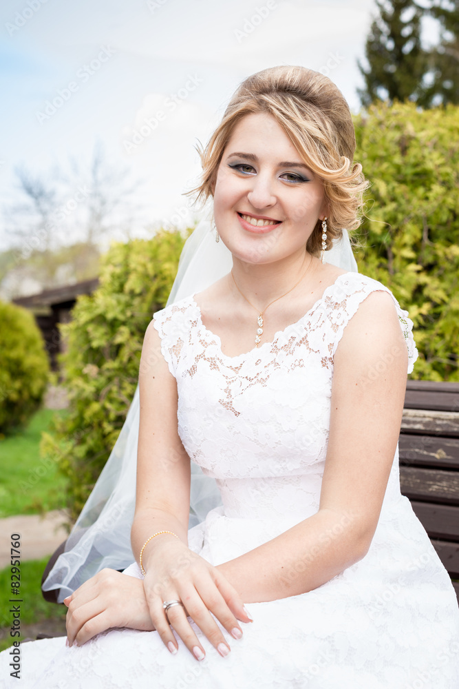 portrait of happy smiling bride sitting on bench at park portrait of happy smiling bride sitting on bench at park