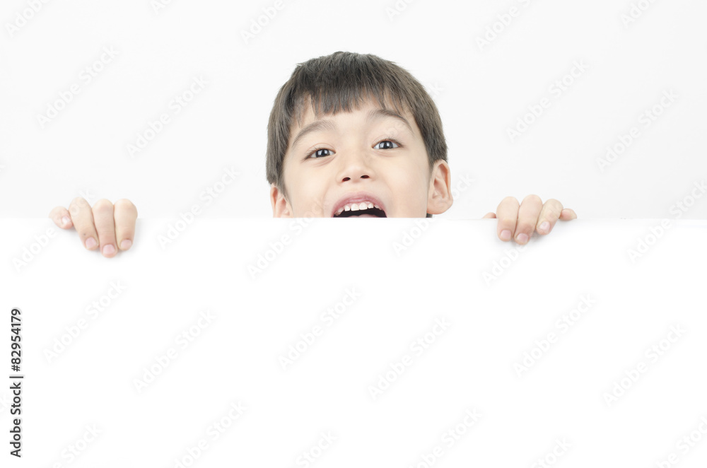Little boy with surprise face behind the whiteboard Little boy with surprise face behind the whiteboard