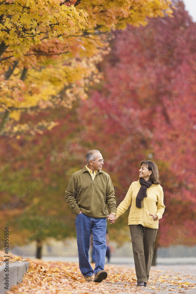 Hispanic couple holding hands outdoors in autumn Hispanic couple holding hands outdoors in autumn