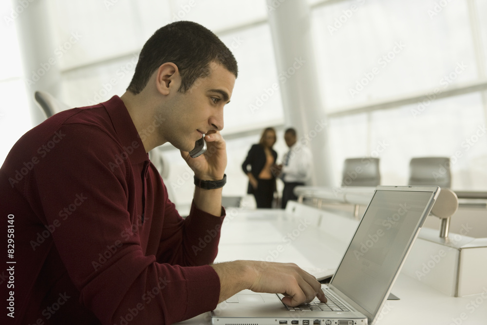 Mixed race businessman working on laptop