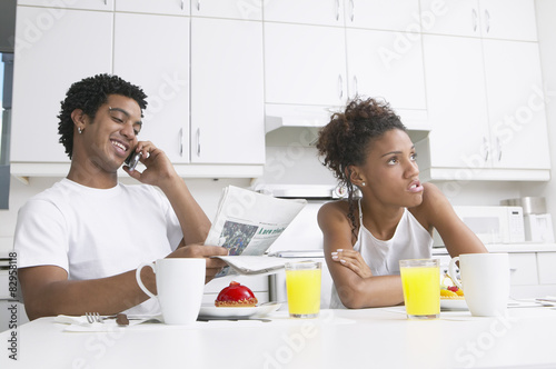 Frustrated African woman in kitchen with boyfriend photo