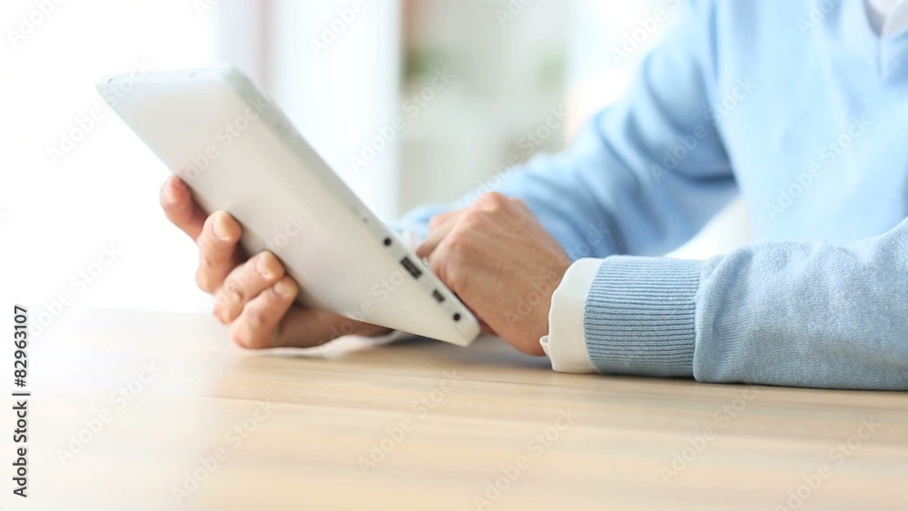 Closeup of man's hand sliding on tablet screen Closeup of man's hand sliding on tablet screen