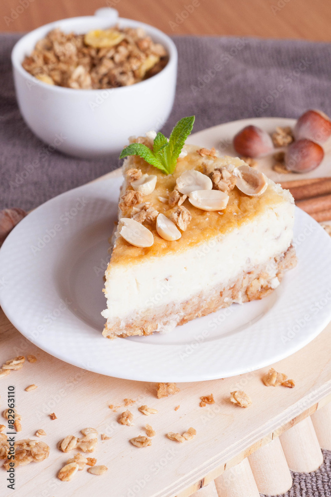piece of cheesecake with nut on wooden board