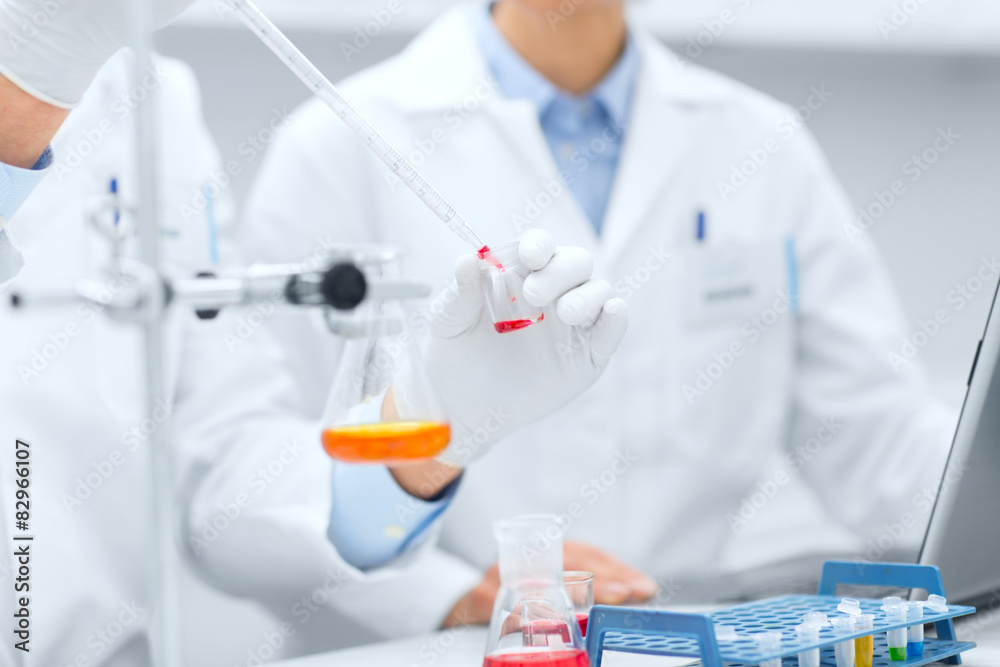 close up of scientists filling test tube in lab close up of scientists filling test tube in lab
