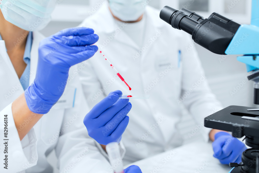 close up of scientists filling perti dish in lab close up of scientists filling perti dish in lab