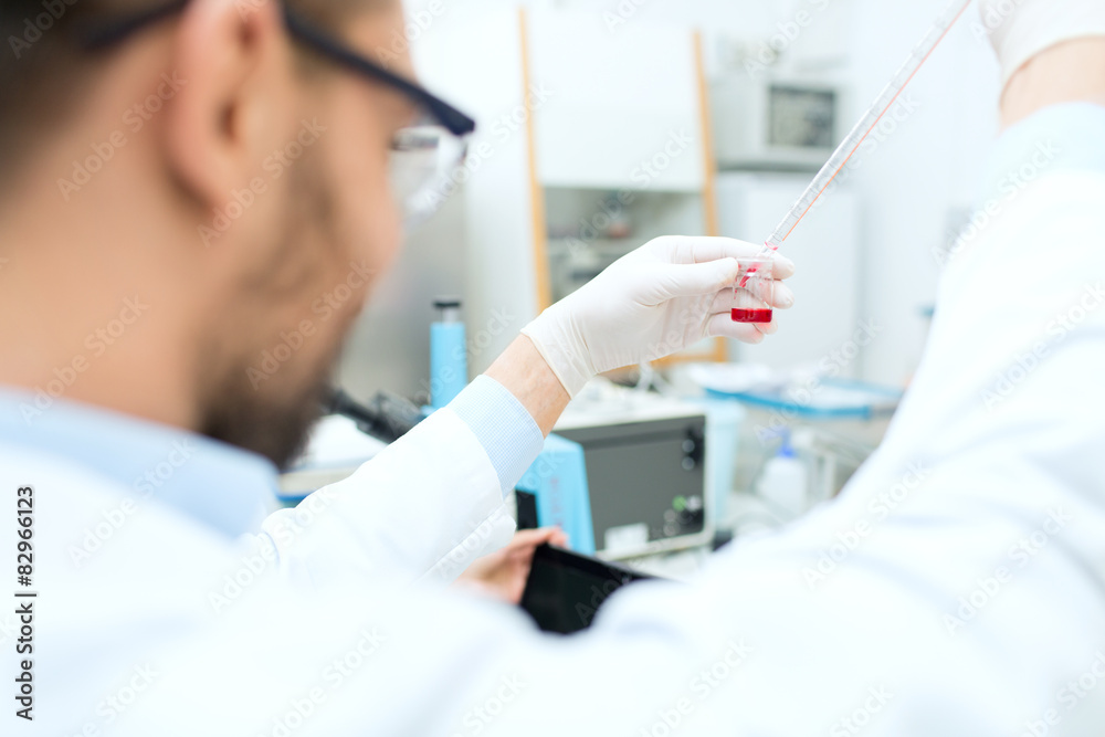 close up of scientist with tube and pipette in lab close up of scientist with tube and pipette in lab