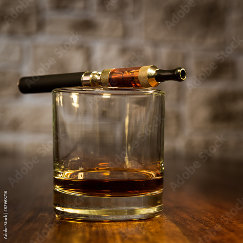 Glas Whiskey mit elektrischer Zigarette im Vintagelook