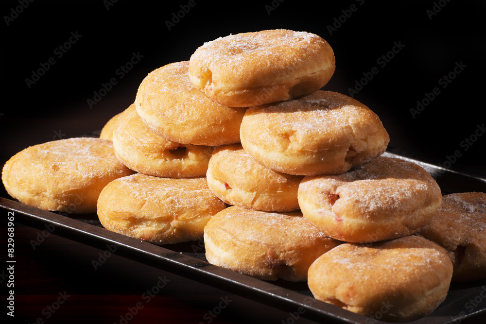 Group of fresh baked cinnamon donuts with raspberry jam. 