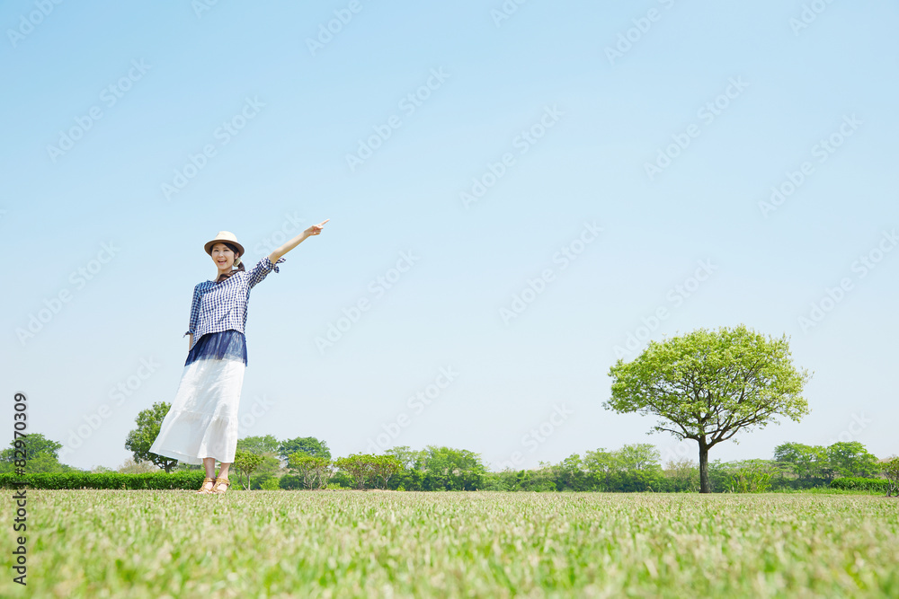 広場に立って指差す女性