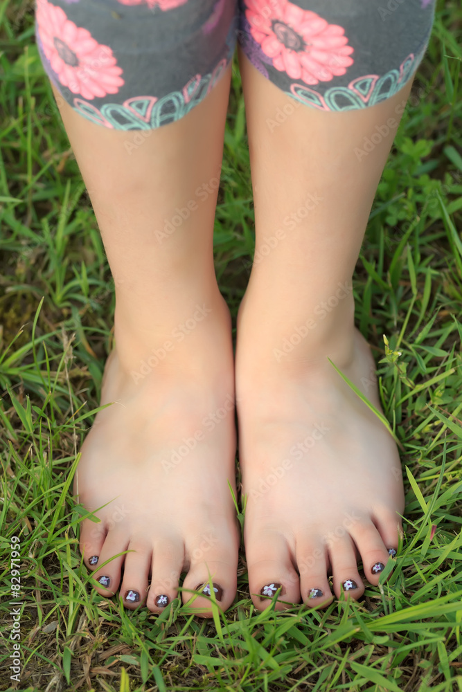 Close-up view of little shoeless girl toes on feet