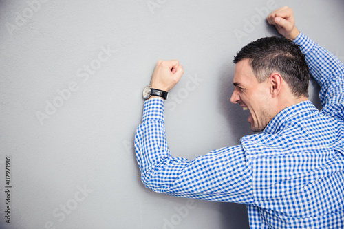 Angry man hitting wall photo