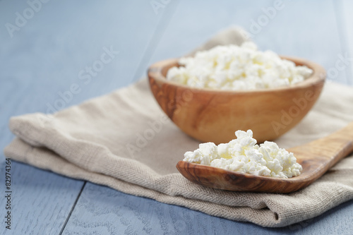 Tableau sur toile cottage cheese in wood bowl on blue wooden table