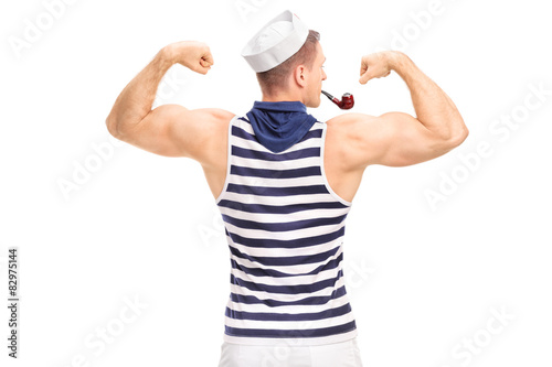 Muscular man in sailor outfit flexing his biceps