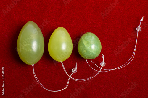 Jade eggs for development of intimate muscles on red background