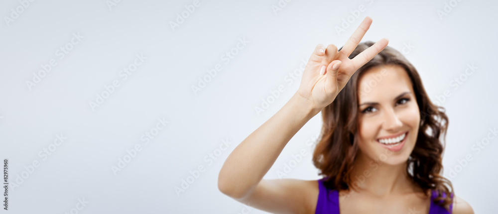Fototapeta premium Woman showing two fingers or victory sign, focus on hand