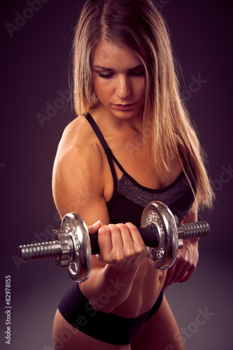 attractive young woman working out with dumbbells - bikini fitne