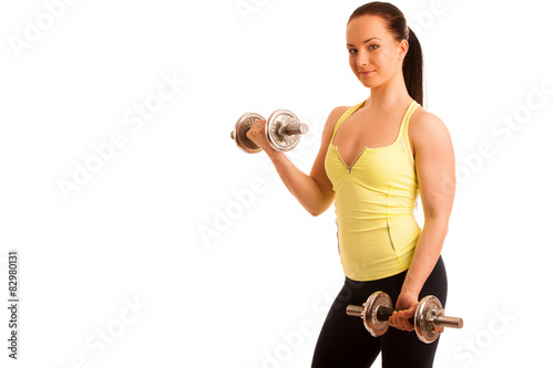 Beautiful young woman working out with dumbels in fitness gym photo