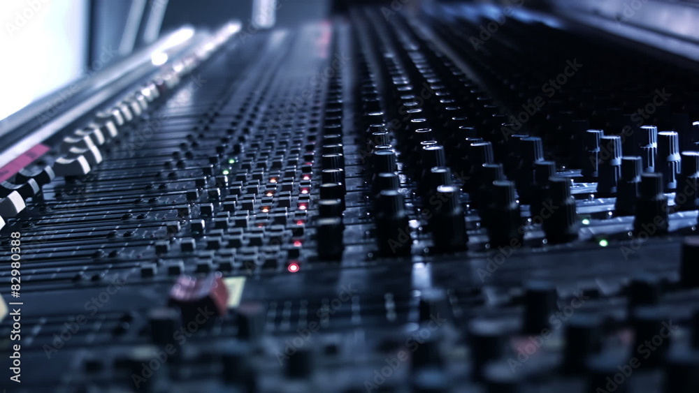 Audio Engineer sticking tape to his mixing console desk Audio Engineer sticking tape to his mixing console desk