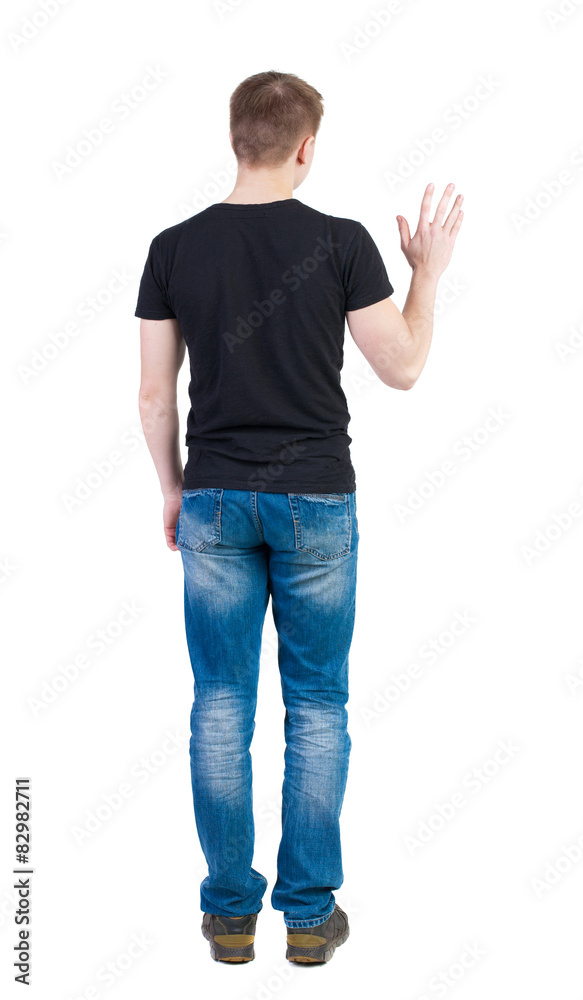 Back view of handsome man in t-shirt greeting waving from his h Back view of handsome man in t-shirt greeting waving from his h