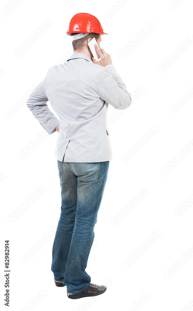 Backview of business man in construction helmet stands and enjoy Backview of business man in construction helmet stands and enjoy