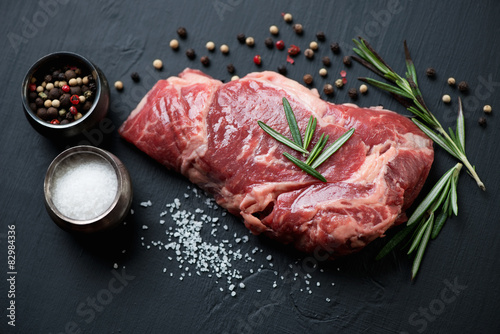 Fotografie Raw ribeye steak with seasonings, close-up, studio shot