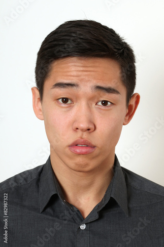 Strict young Asian man looking at camera