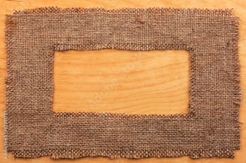 Frame made of burlap  lying on a wooden surface