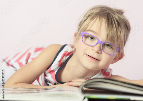 Photo of beautiful kid girl on bed at home photo