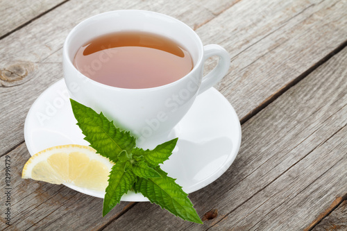 Green tea with lemon and mint on wooden table