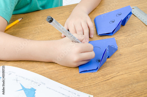 Little boy drawing on paper art origami