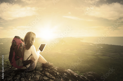 Female hiker using tablet at mountain