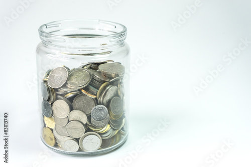 Isolated coins in jar - financial concept.