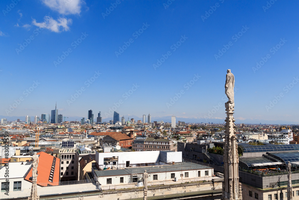 Cathedral statue and view of Milan cityscape