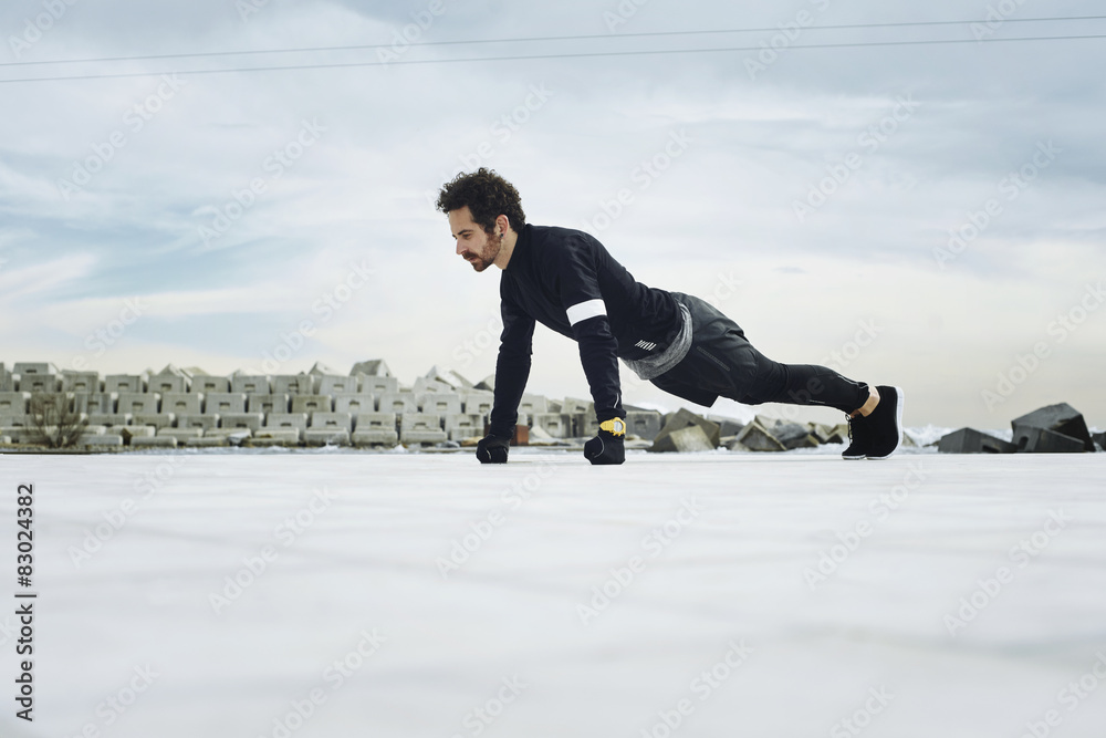 Naklejka premium Athletic man doing push ups before going for a run