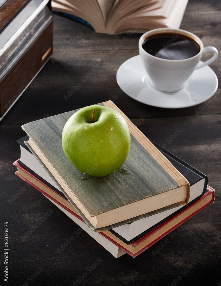 Green apple on top of books