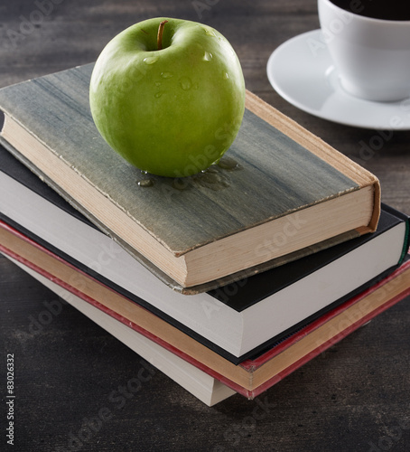 Green apple on top of books