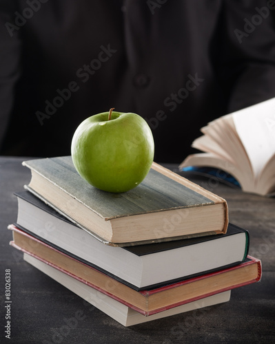 Obraz na płótnie Green apple on top of books w salonie